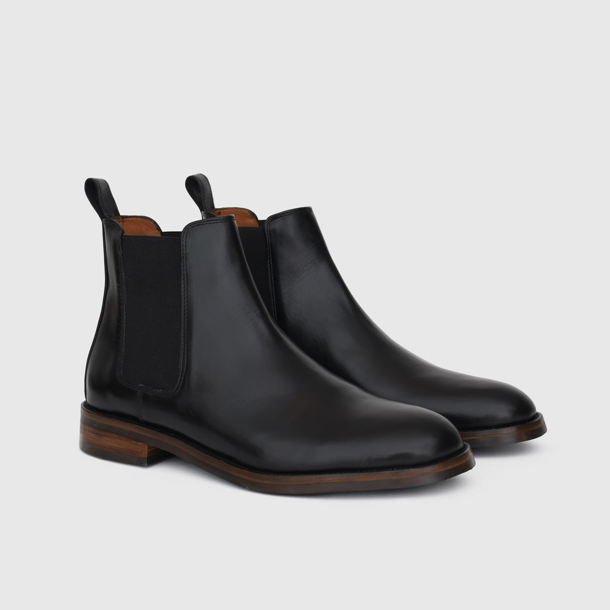 Victorian Chelsea Boot noire, paire vue de trois quarts avec panneaux élastiques et languettes arrière.
