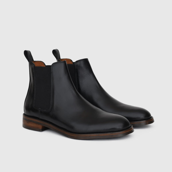 Victorian Chelsea Boot noire, paire vue de trois quarts avec panneaux élastiques et languettes arrière.